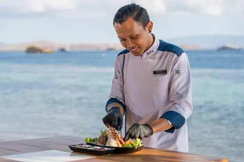 Our chef plating a dish beside the sea