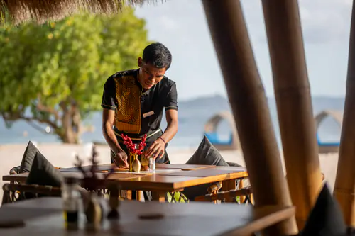 A server laying a table at the Sunset Restaurant