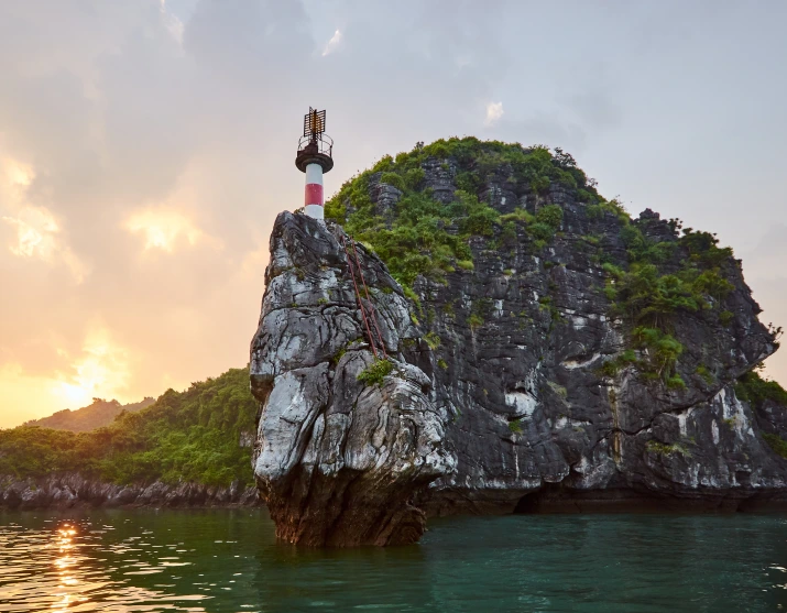 Rocky island and lighthouse at sunset