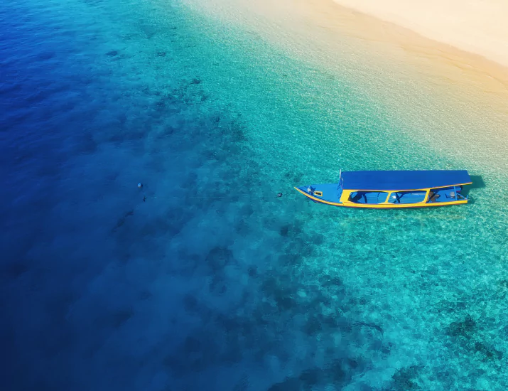 Aerial view of a boat in turquoise water off Bali